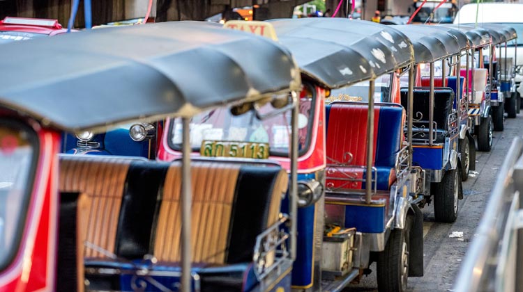 Auf Kundschaft wartende Tuk-Tuks vor dem Großen Palast und dem Chatuchak-Markt in Bangkok