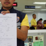 Keine Krankenversicherungspflicht - Beamter der Phuket Immigration zeigt Antragsformular